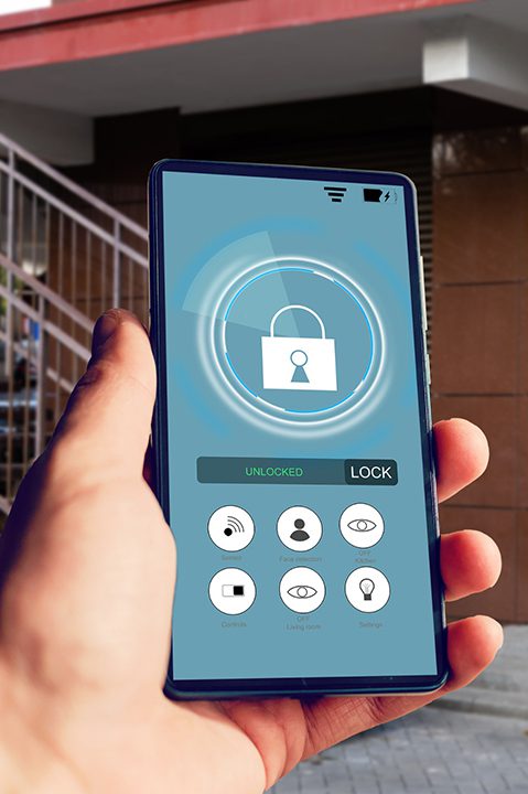 Female hand holding phone with smart home application for access to all of the controls Female hand holding phone with smart home application for access to all of the controls